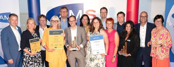 Helge Röder (Bildmitte) und Mitarbeiter des AMS Liezen bei der Preisverleihung mit den beiden AMS-Vorständen Johannes Kopf (links außen) und Petra Draxl (rechts außen) sowie Karl Heinz Snobe (Landesgeschäftsführer, 2. von rechts)