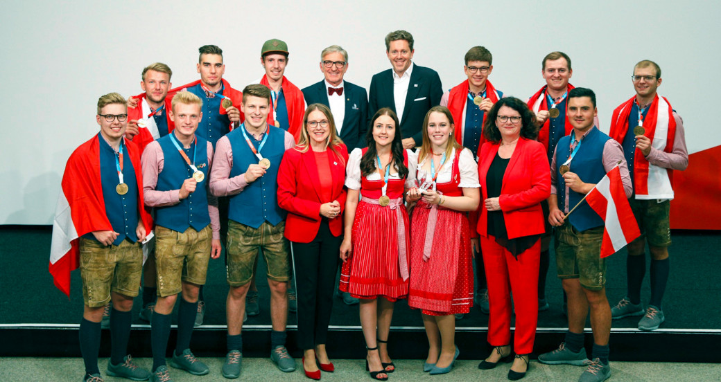 Die österreichischen Goldmedaillengewinner mit (4. bzw. 5. v. l., hinten) Josef Herk, Präsident der Wirtschaftskammer Steiermark, und Harald Mahrer, Präsident der Wirtschaftskammer Österreich, sowie (4. bzw. 7. v. l., vorne) Wirtschaftsministerin Margarete Schramböck und Doris Wagner, Sektionschefin im Bildungsministerium.